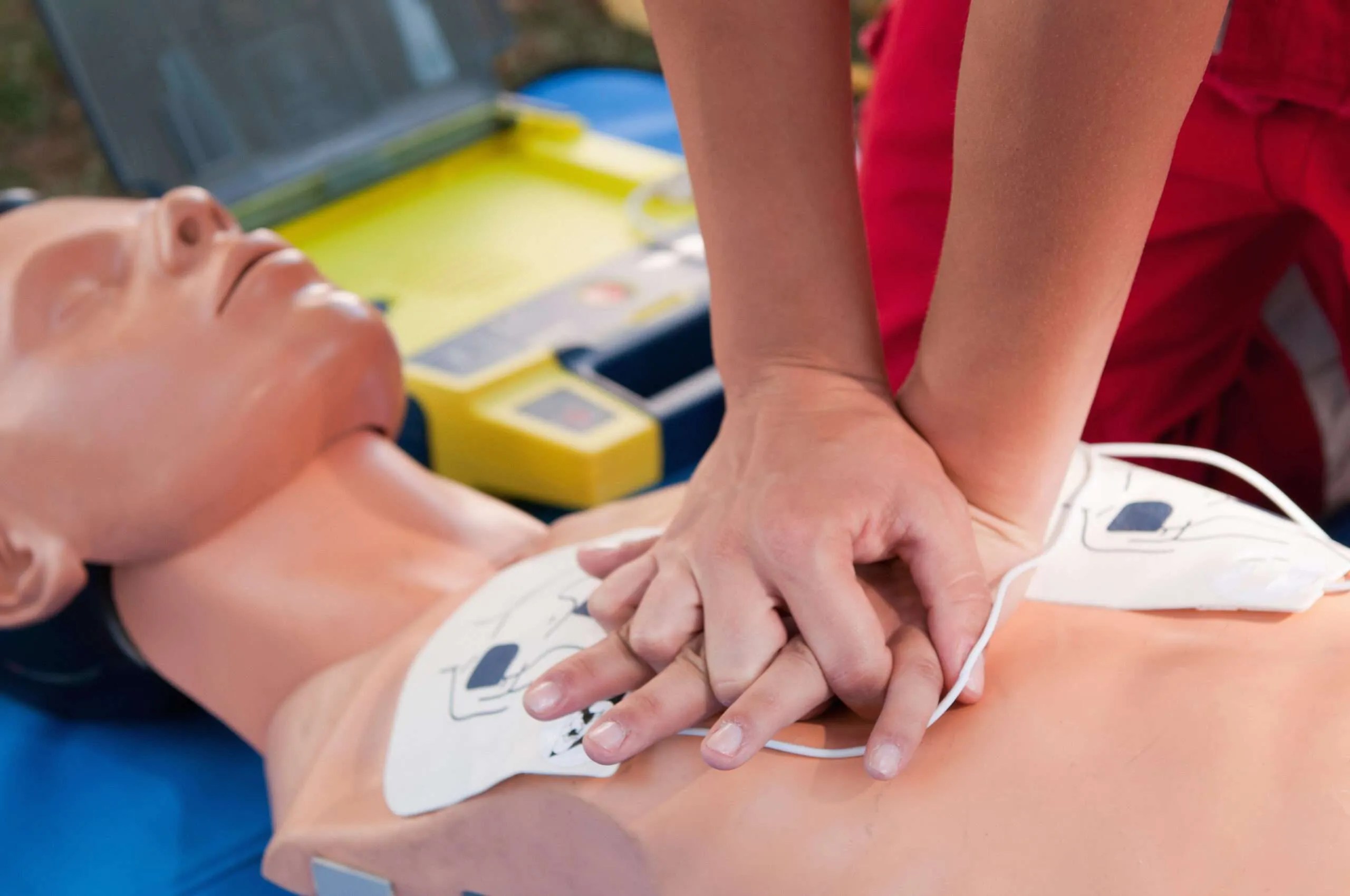 Practicing defibrillator CPR procedure on a dummy
