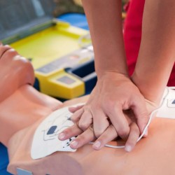 Practicing defibrillator CPR procedure on a dummy