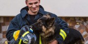 firefighter plays with a sheepdog, hugs, rejoices